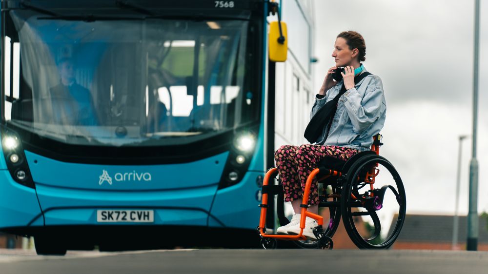 A wheelchair user in front of a bus