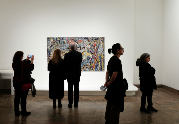 People stood in front of a painting in an art gallery.
